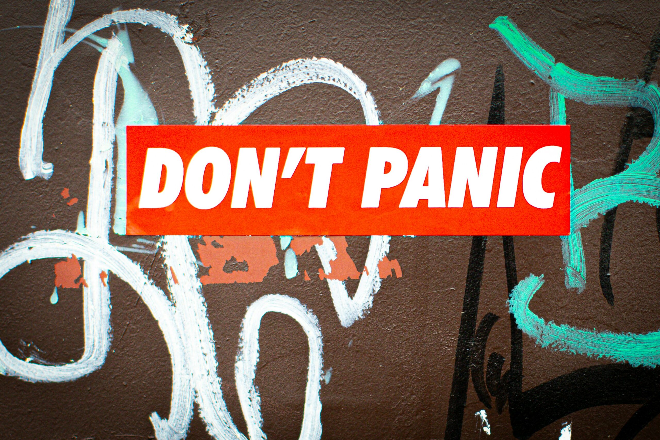 a red don't panic sticker on a wall