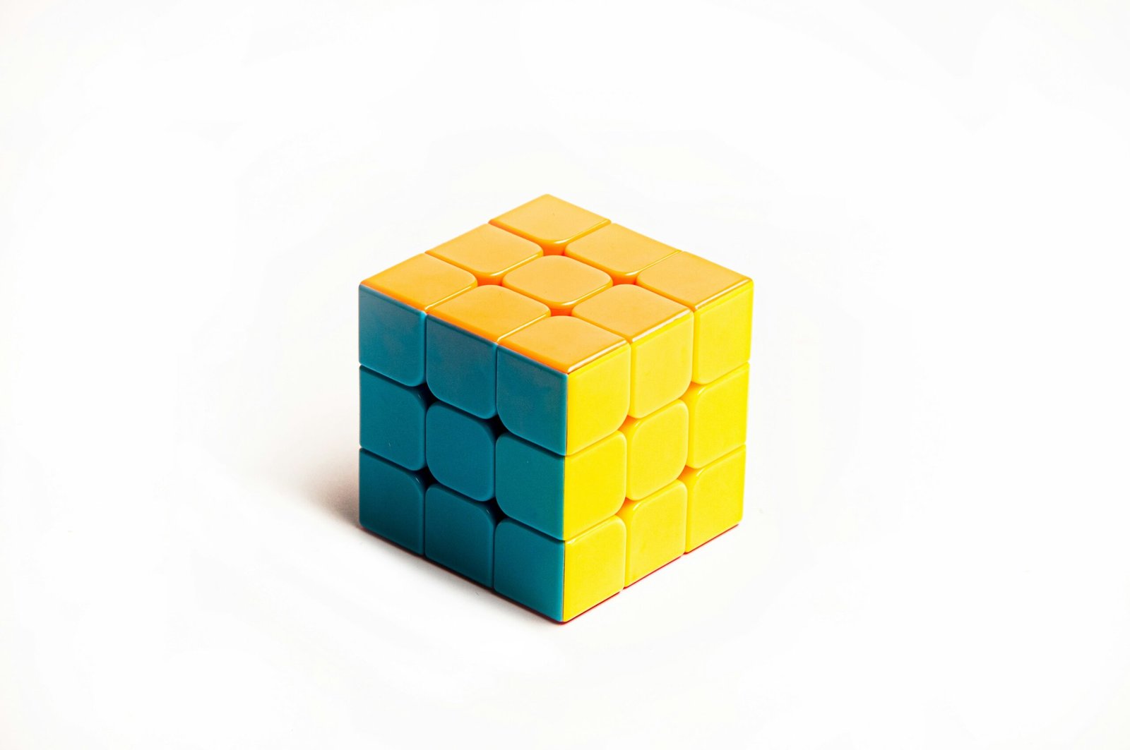 a yellow and blue cube sitting on top of a white surface